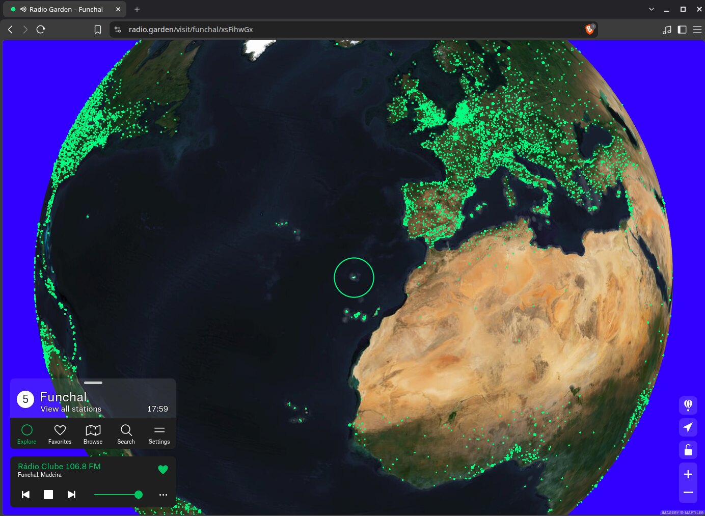 Radio Garden aberto no navegador Brave mostrando o globo terrestre em imagem de satélite, coberto por milhares de pontos verdes concentrados na Europa e na costa africana. Um círculo destaca o arquipélago da Madeira e o player inferior toca a Rádio Clube 106.8 FM de Funchal